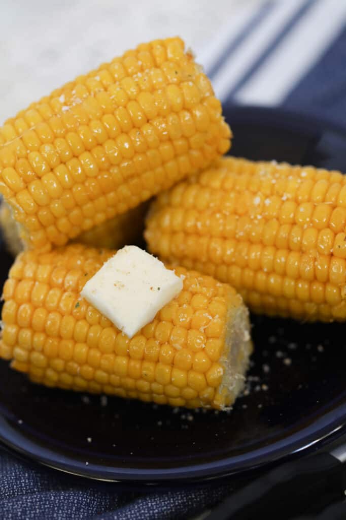 air fryer frozen corn on the cob on a blue plate with butter