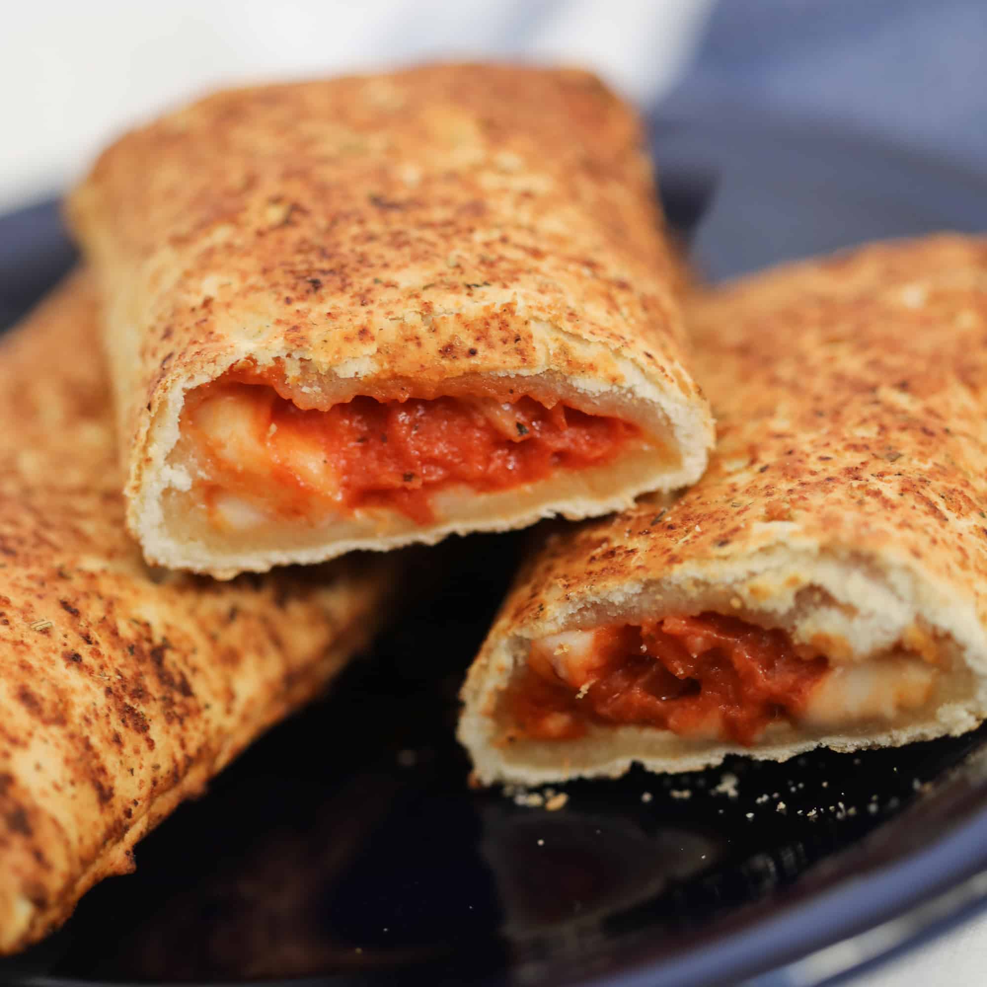 air fryer hot pockets cut in half on a blue plate after cooking