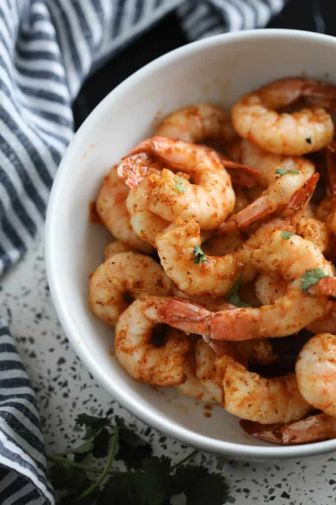 air fryer shrimp no breading with a cajun seasoning in a white bowl