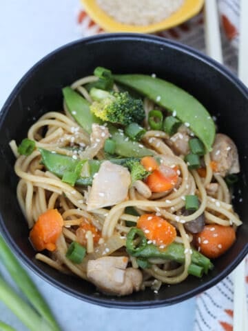 the chicken lo mein instant pot recipe with chopsticks on a white background