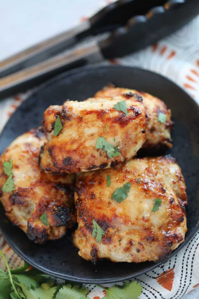 the frozen chicken thighs in air fryer recipe with cilantro on a black plate