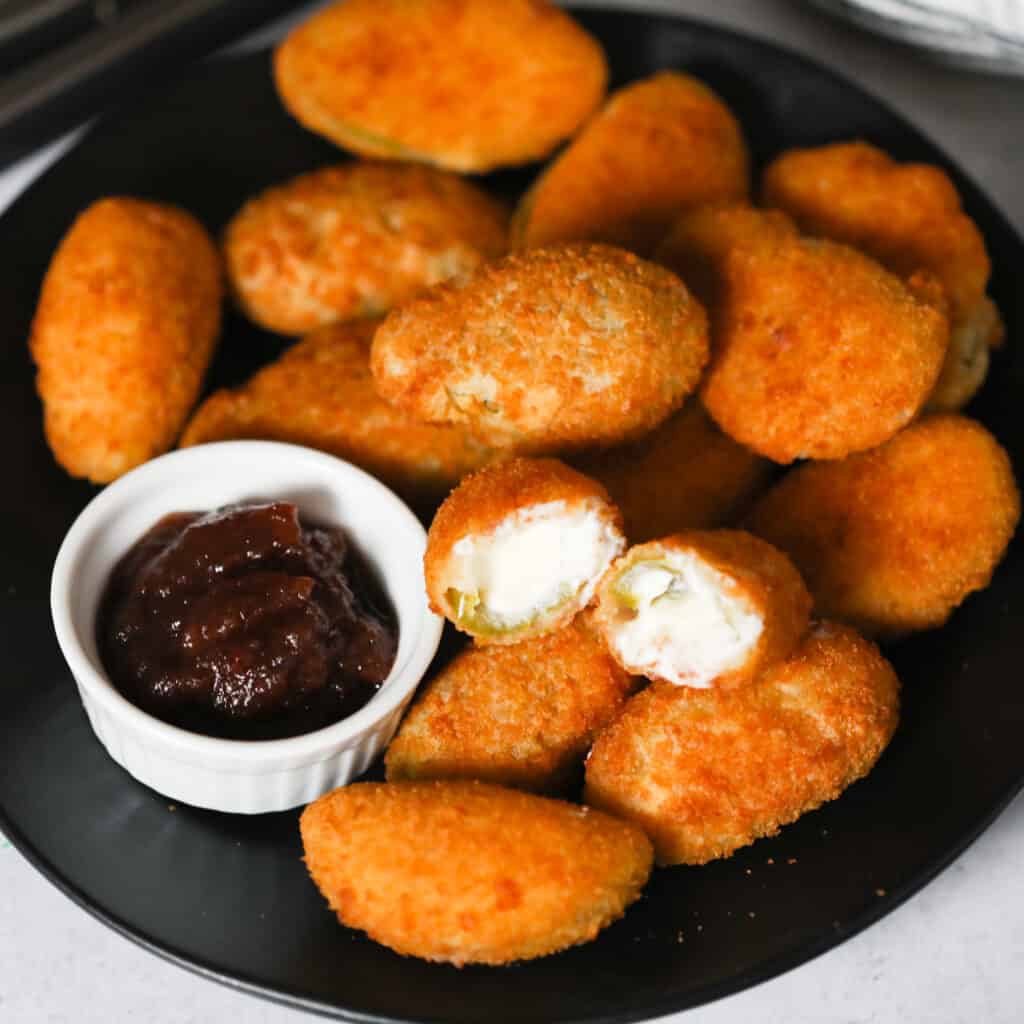 frozen jalapeno poppers in air fryer after cooking on a black plate