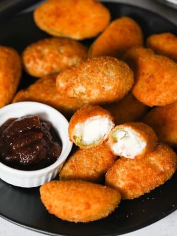 frozen jalapeno poppers in air fryer after cooking on a black plate