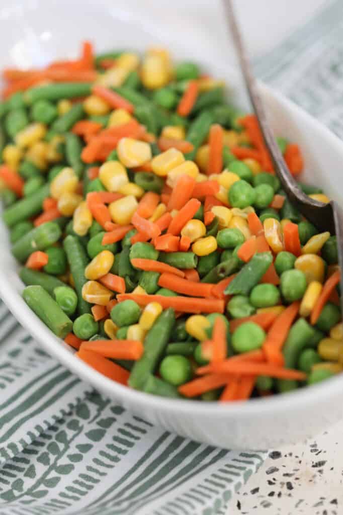 the frozen vegetables in air fryer after cooking in a white serving dish