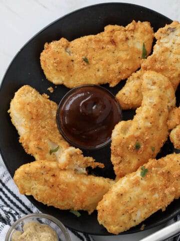keto air fryer chicken tenders with almond flour and parmesan on a black plate
