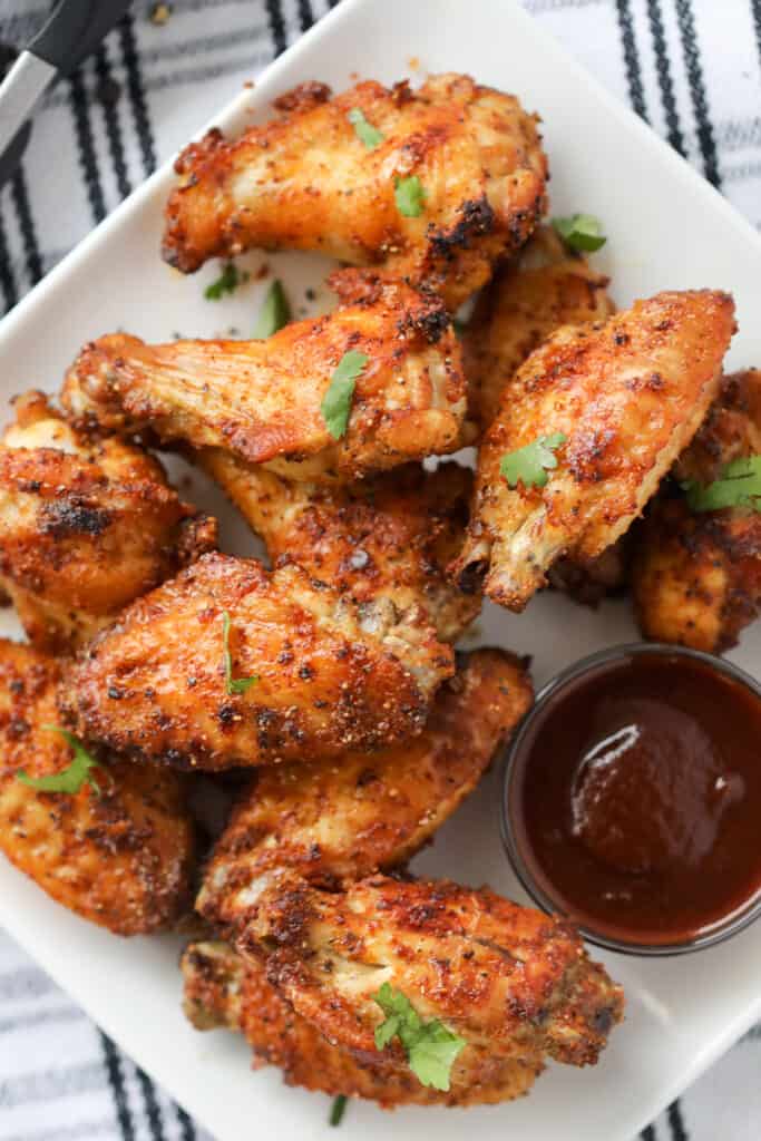 air fryer chicken wings dry rub on a white plate after cooking