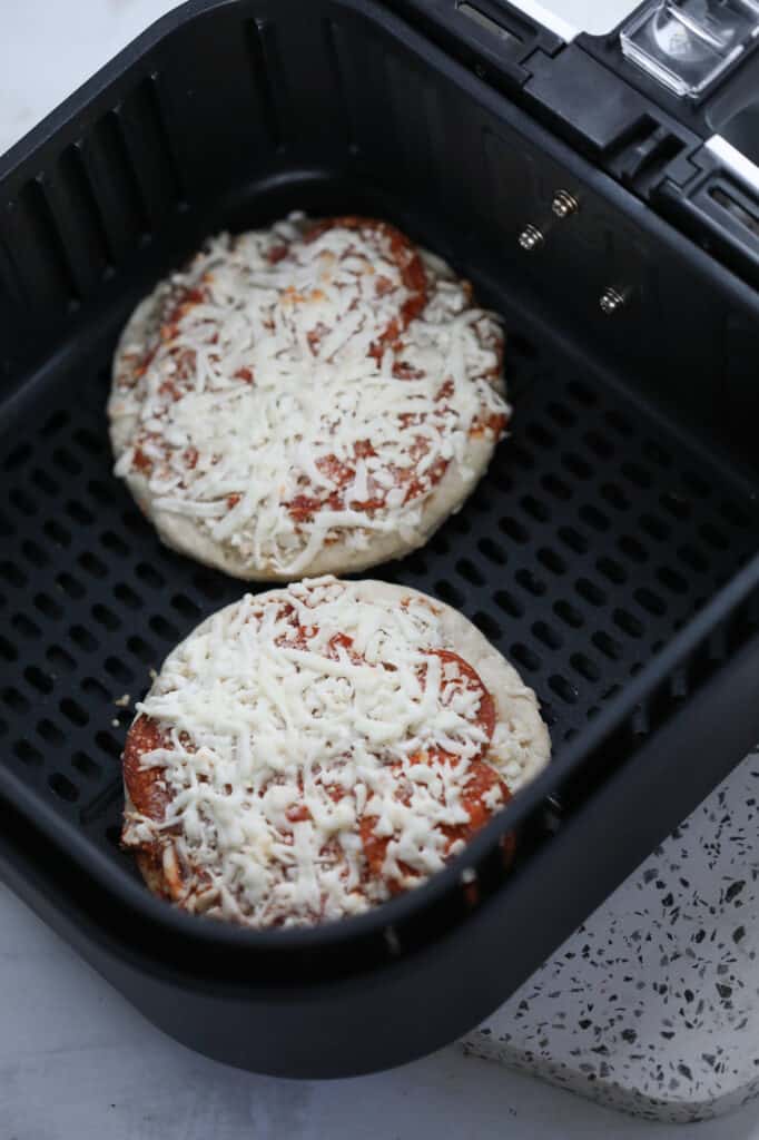 frozen pizza air fryer recipe starts with putting 2 frozen pizzas in the air fryer oven