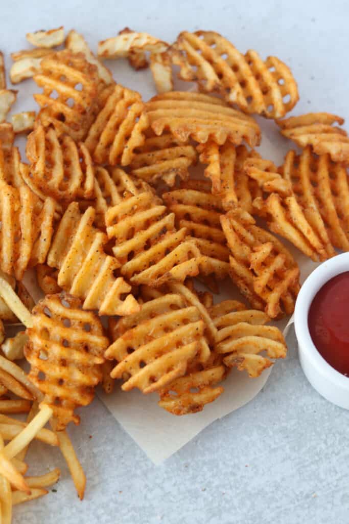 the frozen waffle fries in air fryer spread on a white board after cooking