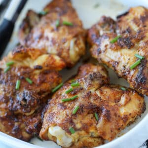 air fryer chicken thighs bone in skin on recipe on a white plate after air frying
