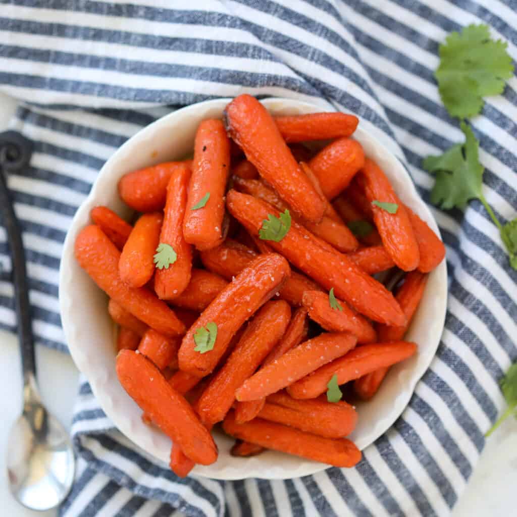 air fryer baby carrots top down view after cooking on a black and white cloth