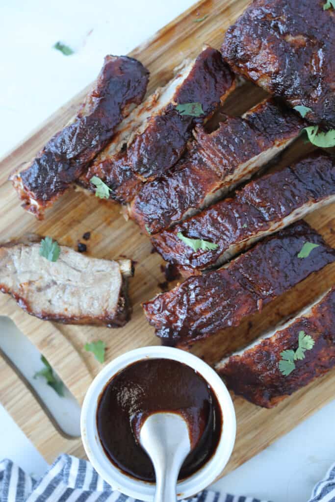 air fryer pork ribs on a cutting board with bbq sauce after cooking