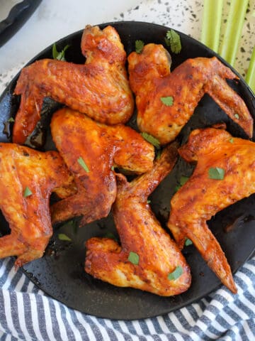 whole chicken wings in air fryer on a black plate ready to serve
