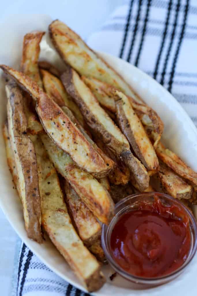 air fryer steak fries after cooking in a white dish