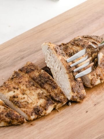 baked thin chicken breast after baking and getting sliced on a cutting board