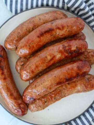 chicken sausage in air fryer roasted on a white plate after cooking