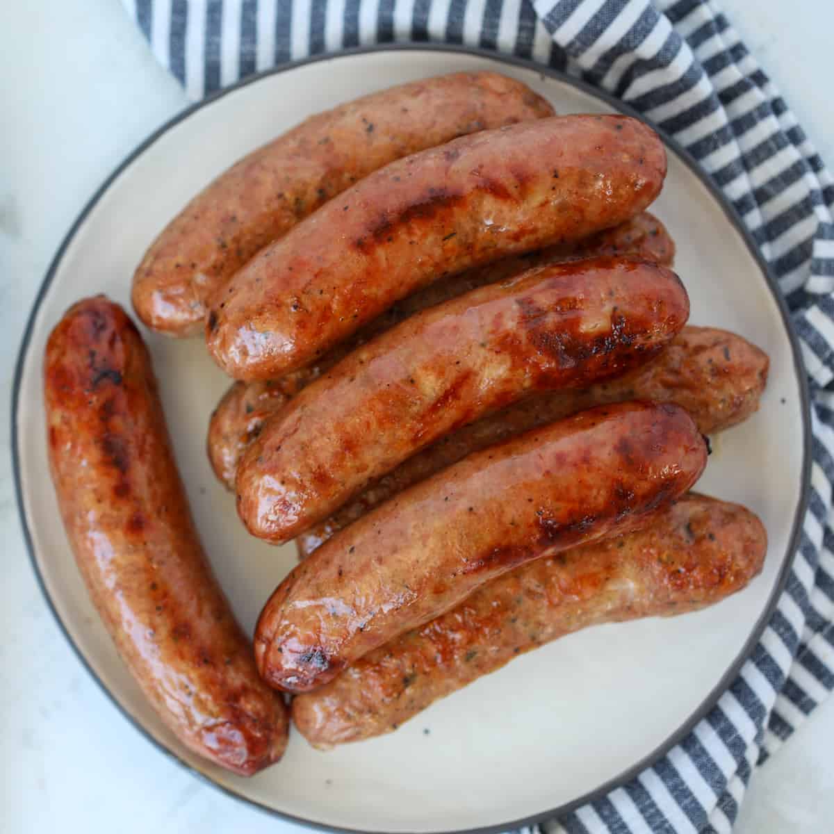 chicken sausage in air fryer roasted on a white plate after cooking