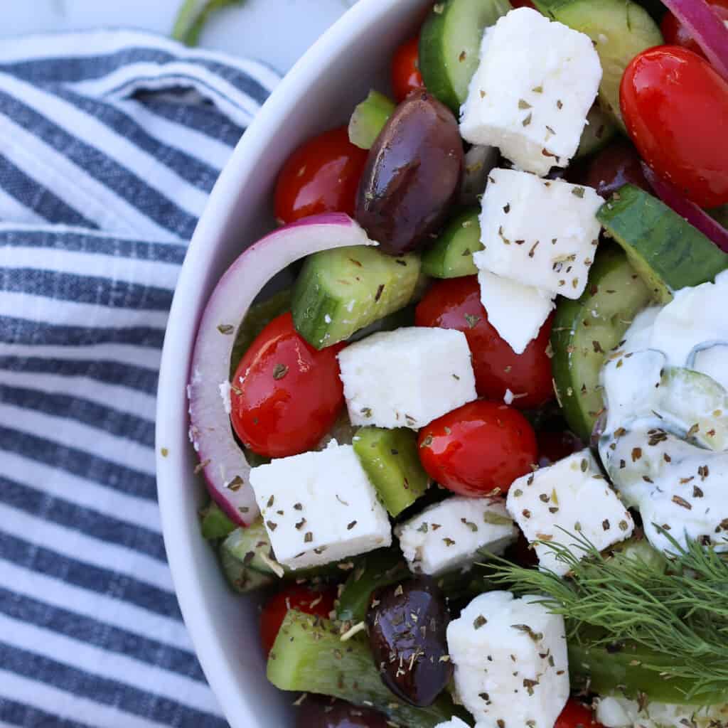 greek tomato cucumber salad in a white bowl