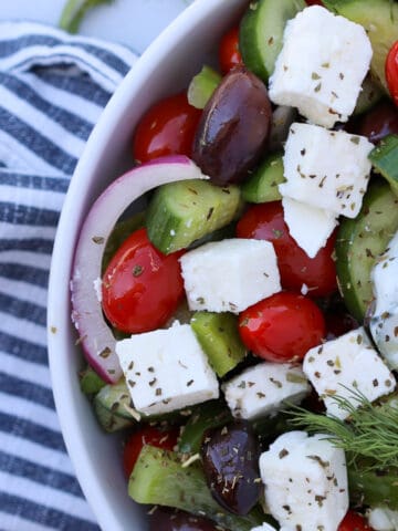 greek tomato cucumber salad in a white bowl