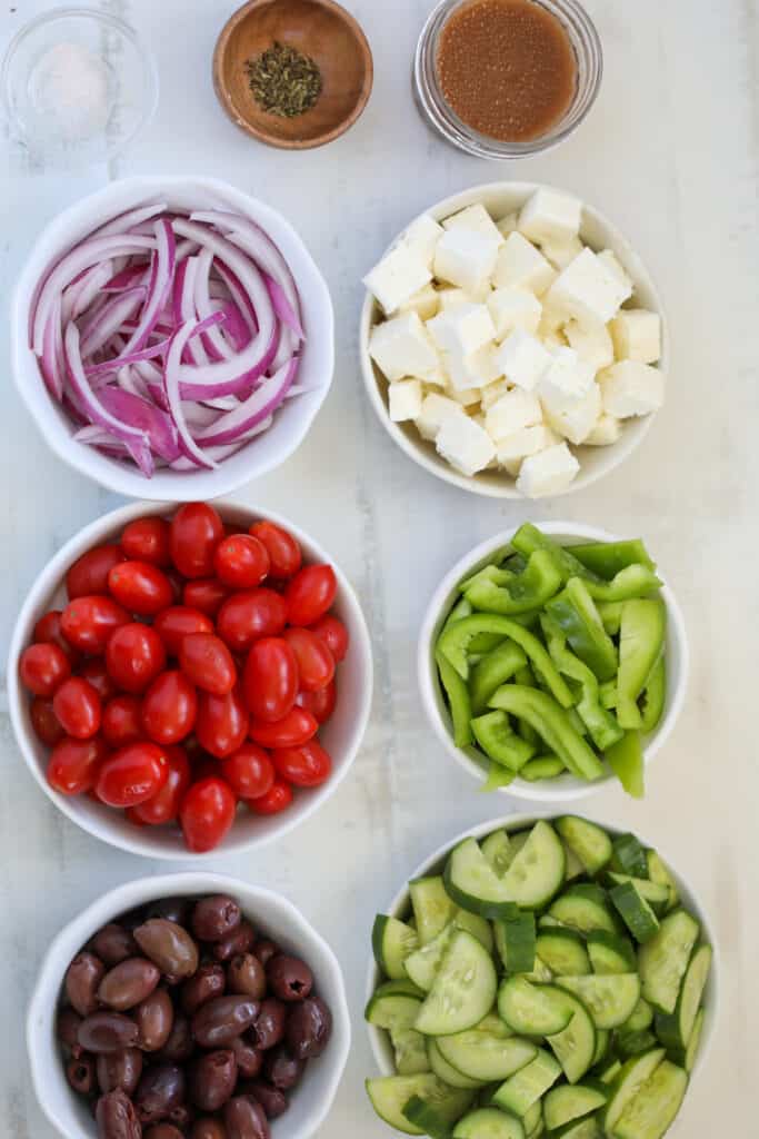 ingredients for greek salad on a white tray