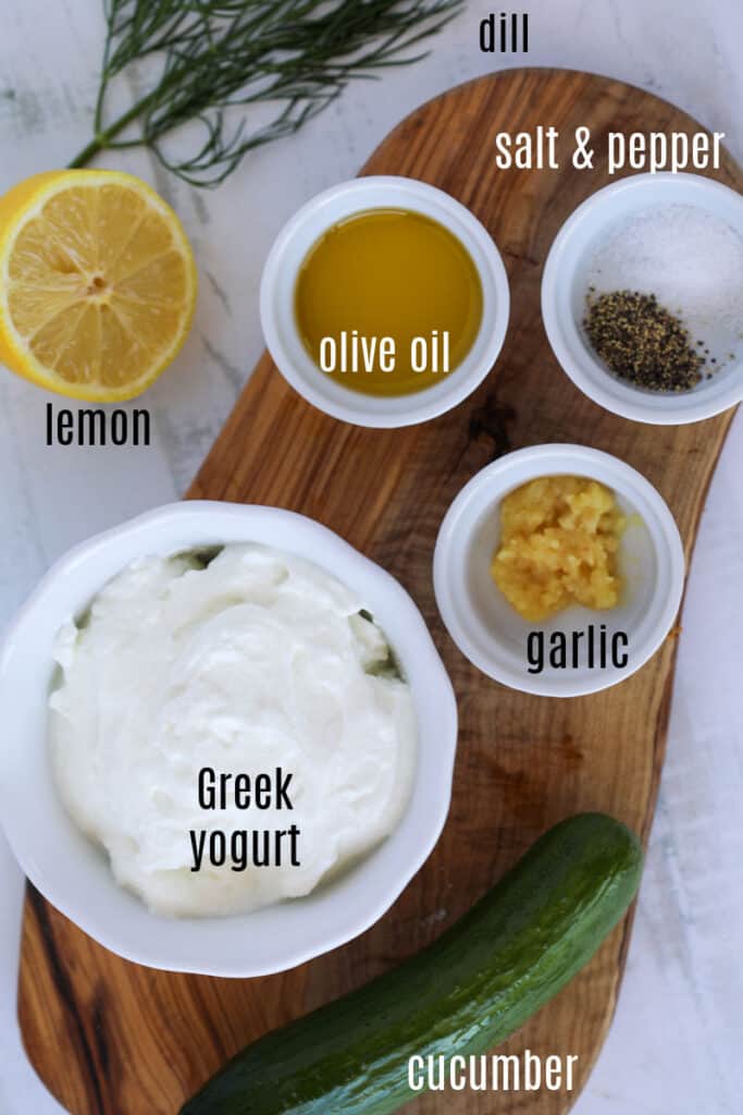 the ingredients for tzatziki sauce on a cutting board