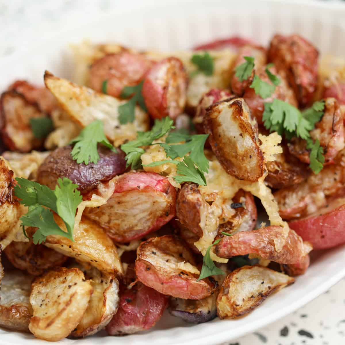 close up of radishes in air fryer with cheese