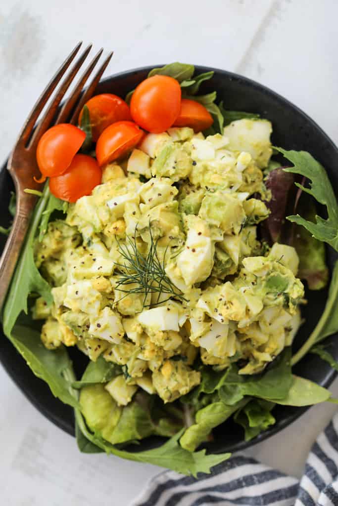 egg and avocado salad on a black plate