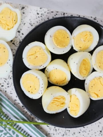 hard boiled eggs in air fryer cut in half served with salt and pepper
