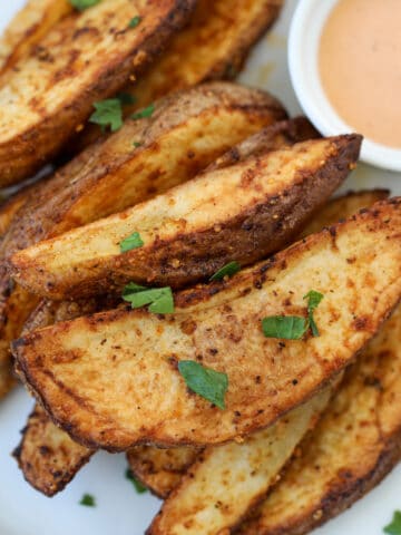 homemade potato wedges air fryer recipe on a white plate with dipping sauce