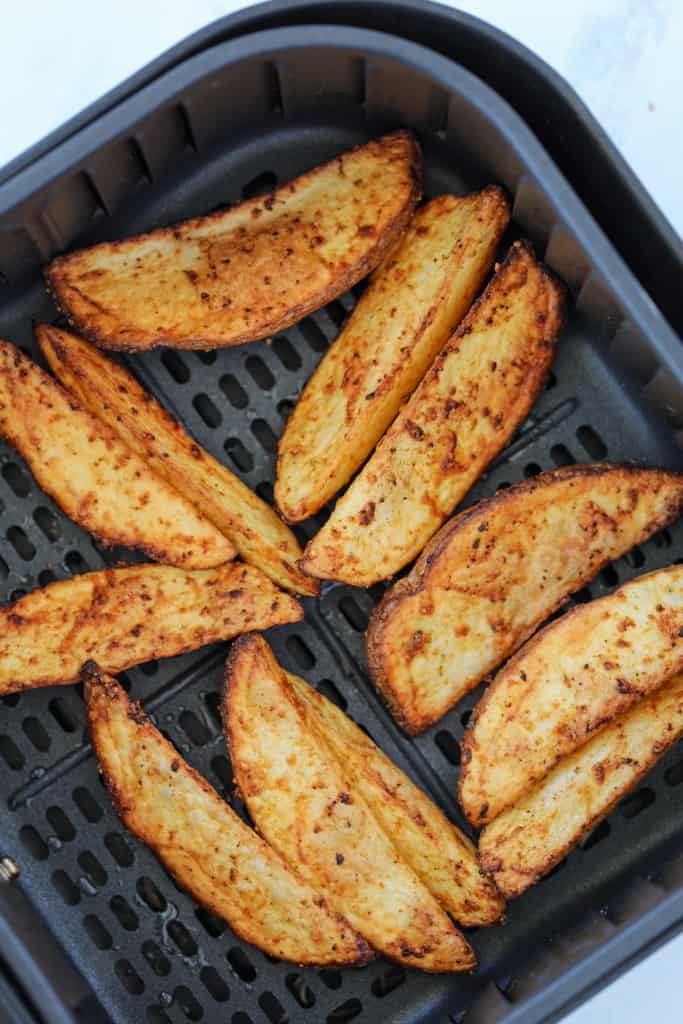 potato wedges in air fryer basket after cooking