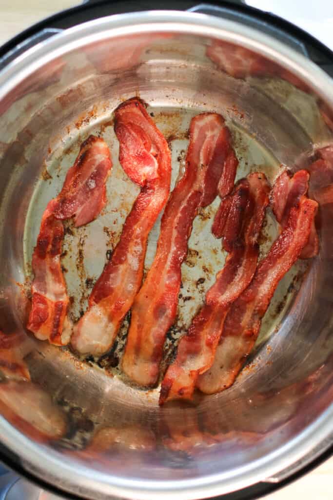 crispy instant pot bacon cooking in a pressure cooker