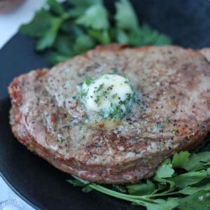 air fryer ribeye steak resting on a plate after cooking