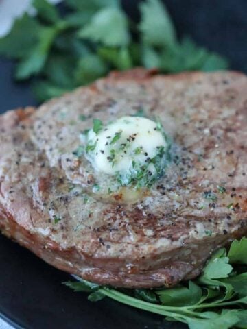air fryer ribeye steak resting on a plate after cooking
