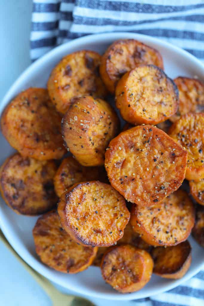 air fryer sweet potato slices after cooking in a white bowl