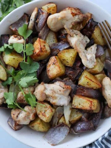 air fryer chicken and potatoes stirred and ready to eat in a bowl with a fork