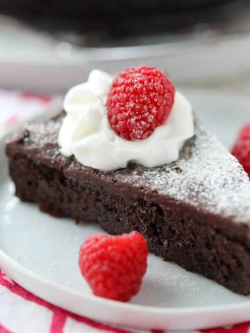 flourless chocolate cake with ganache slice on a white plate