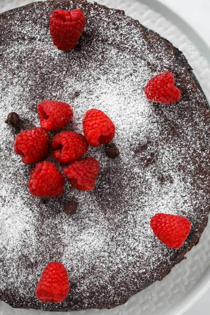 sugar free flourless chocolate torte whole cake on a white platter