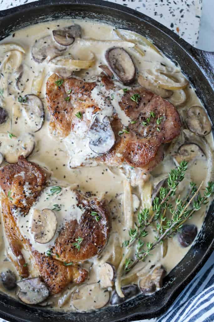 pork shoulder blade steak cooked in a skillet with mushroom and onion sauce
