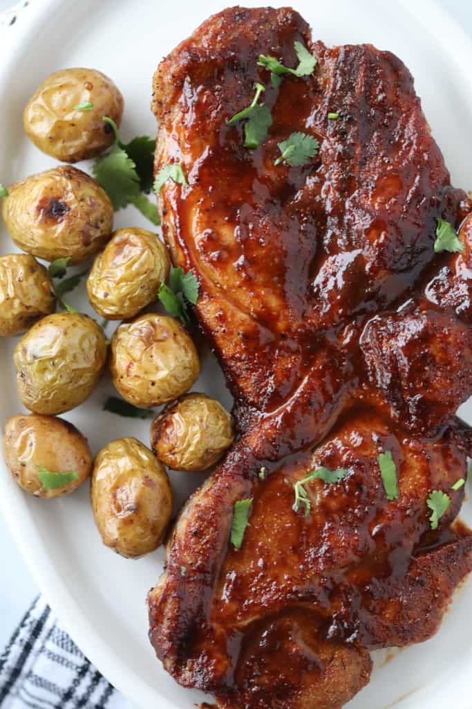 pork steak in air fryer on a white plate with potatoes