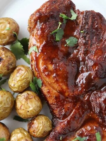 pork steaks in air fryer on a plate with potatoes