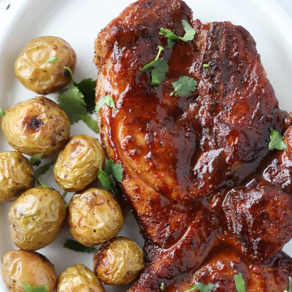 pork steaks in air fryer on a plate with potatoes