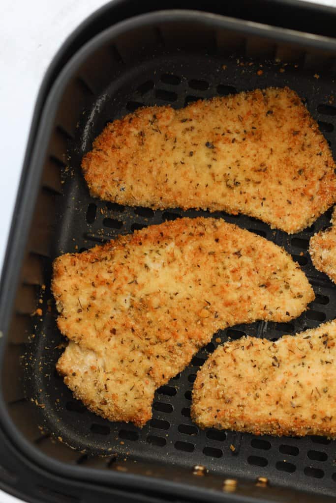 breaded air fryer turkey cutlets in the air fryer basket after cooking