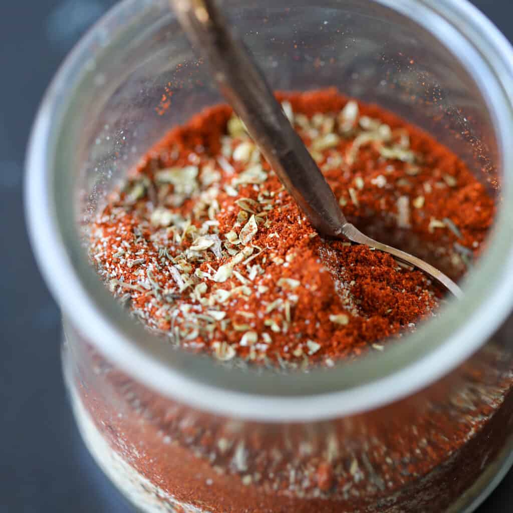 cajun blackened seasoning in a jar with a mini spoon top down view