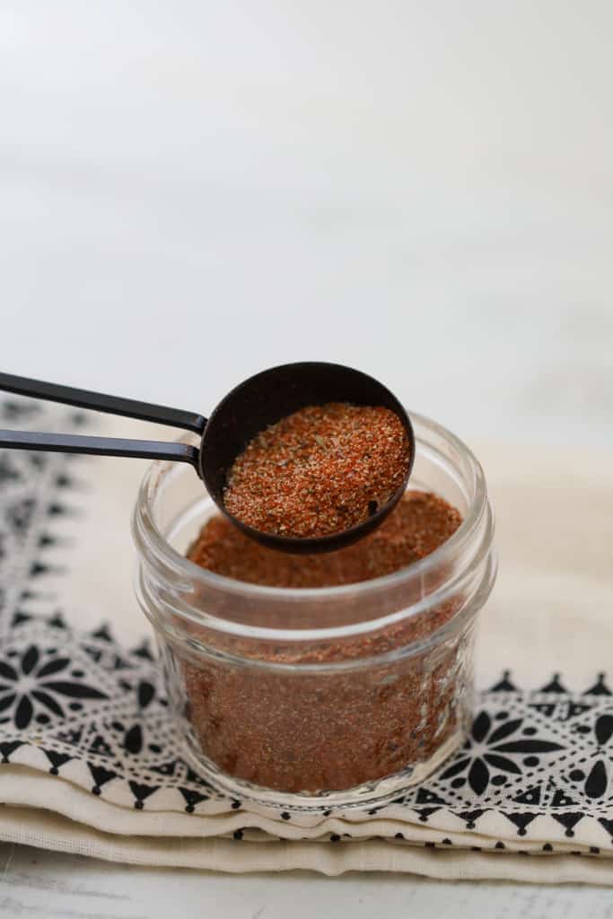 substitute for cajun seasoning in a jar with a tablespoon of creole seasoning on a spoon