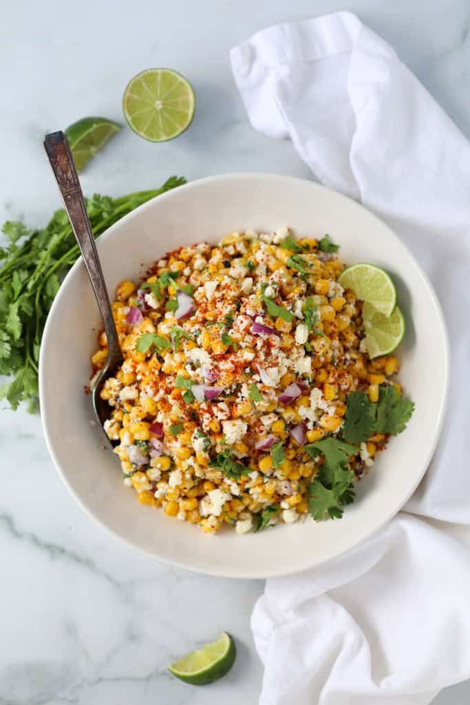frozen elotes salad off the cob on a white background in a white bowl