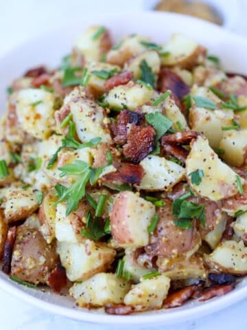german potato salad in instant pot while bowl with bacon and green onions