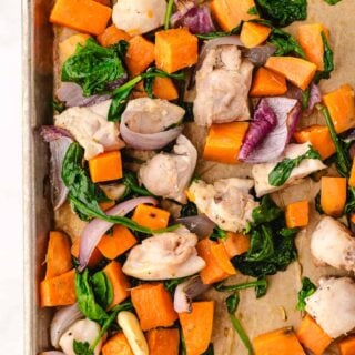 chicken thighs and sweet potatoes close up on a sheet pan