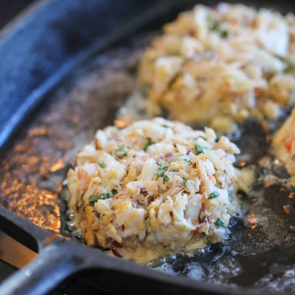 gluten free dairy free crab cakes cooking in a skillet