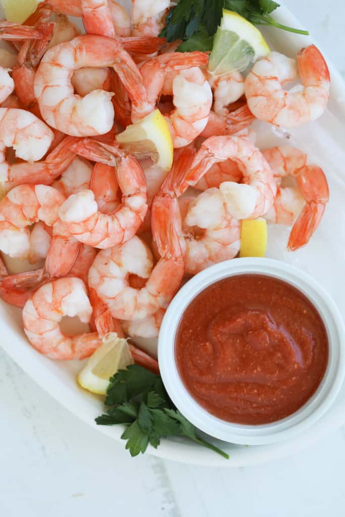 sugar free cocktail sauce recipe for shrimp cocktail on a white platter with shrimp