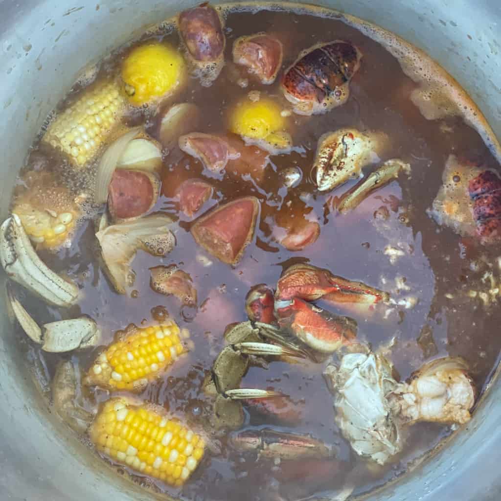 add the potatoes sausage crabs and lobster to the pot