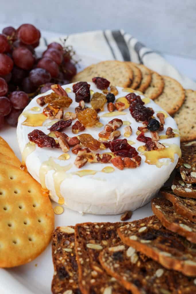 air fryer brie on a tray with crackers an grapes